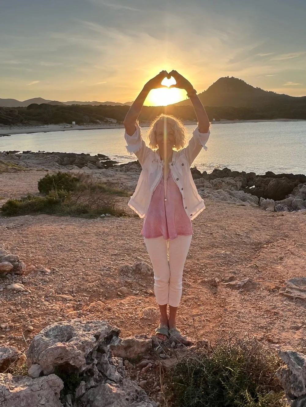 Andrea Gassmann, Yogatherapeutin, in entspannter Pose bei Sonnenuntergang am Meer